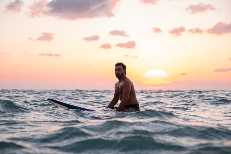 Photo Of Man Riding A Surf Board