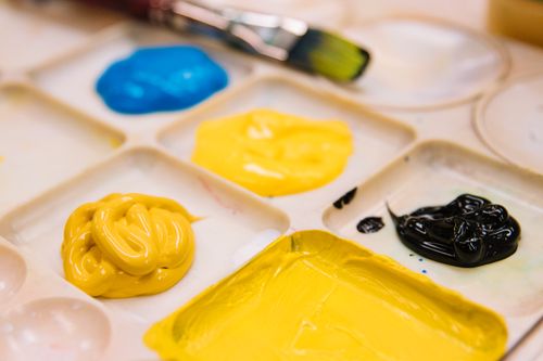 Free Close-up of colorful acrylic paints on a palette with brush, showcasing artistic creativity. Stock Photo