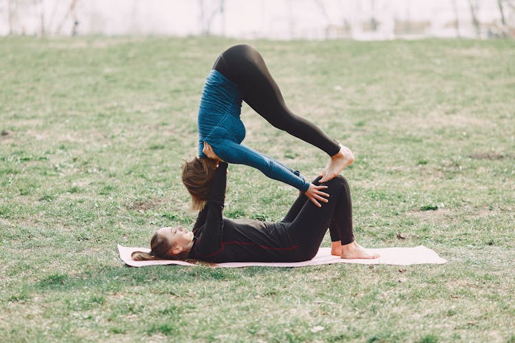 Flexible Women Doing Acro Yoga Exercise Outdoors