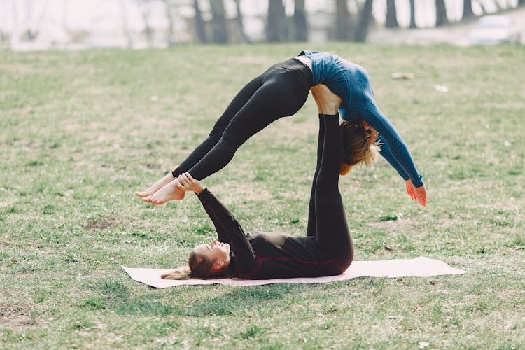 Determine Women Doing Acro Yoga Exercise Outdoors