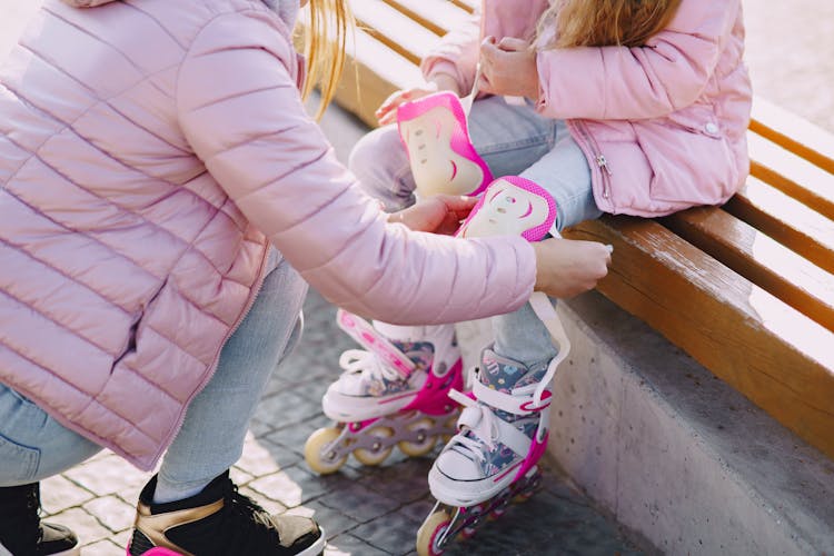 Crop Mother And Daughter Preparing For Roller Skating