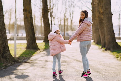 Free Happy mother and daughter strolling hand in hand in city park Stock Photo