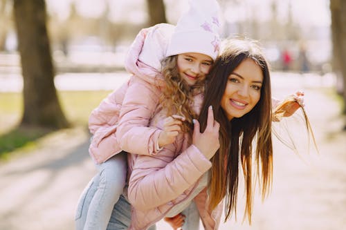 Happy young woman and daughter spending time together in city park