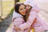 Happy mother and daughter embracing in spring in park