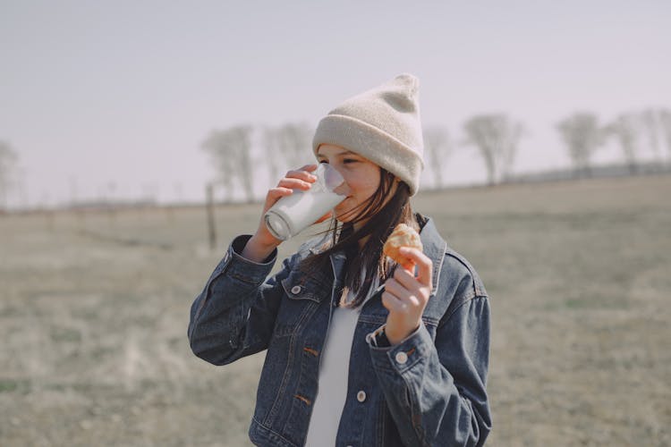 Teen Girl Enjoying Milk And Cookies In Nature