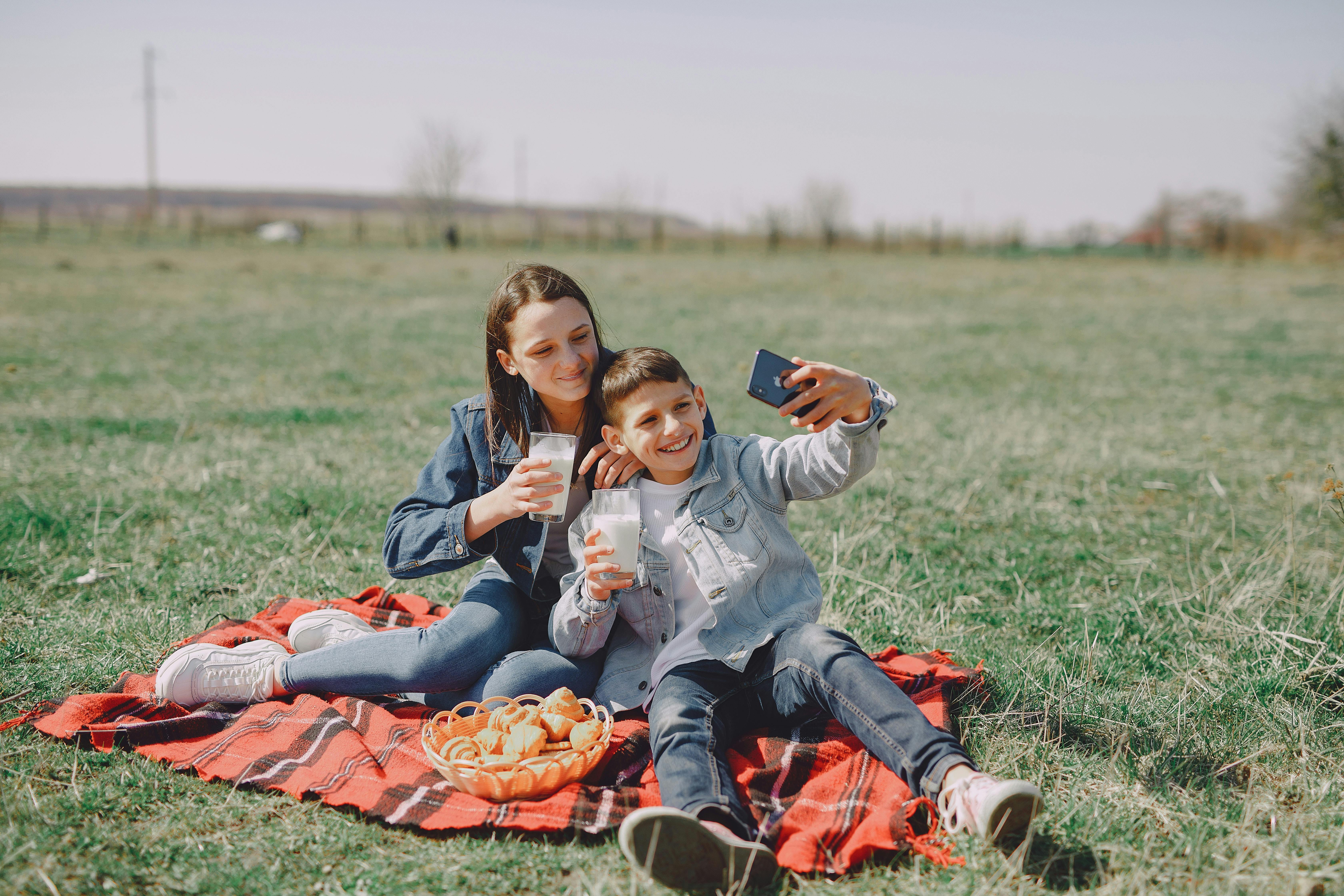 cheerful friends taking selfie on smartphone in countryside