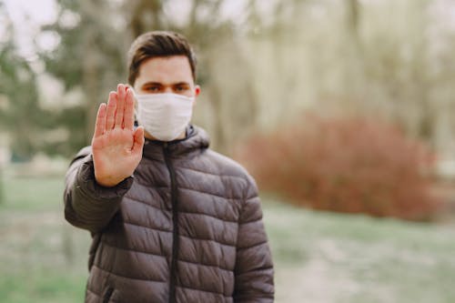 Free Man in medical mask showing stop sign Stock Photo
