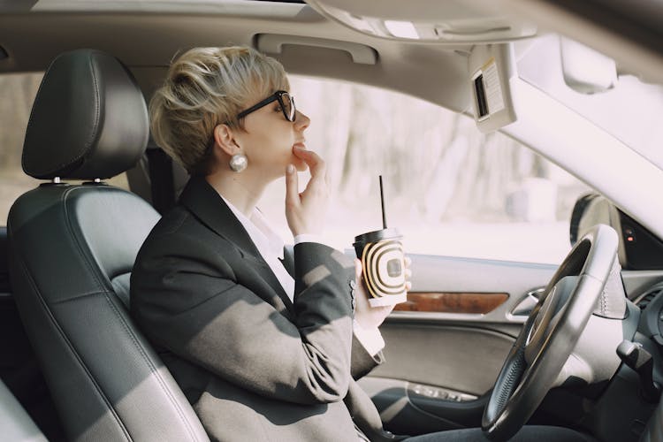 Focused Woman Looking At Mirror In Car