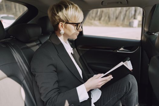 Focused woman checking planner information in car