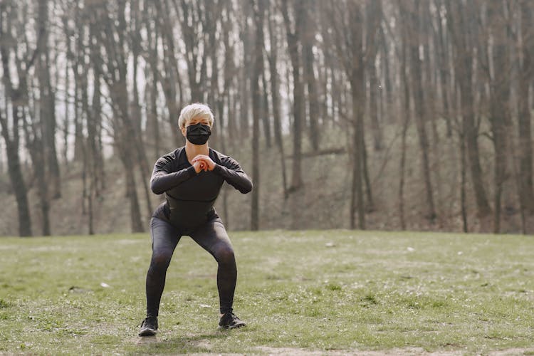 Woman Wearing Face Mask Exercising In Park