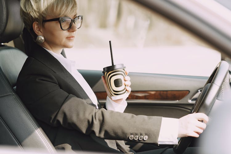 Stylish Woman With Takeaway Coffee Driving Car