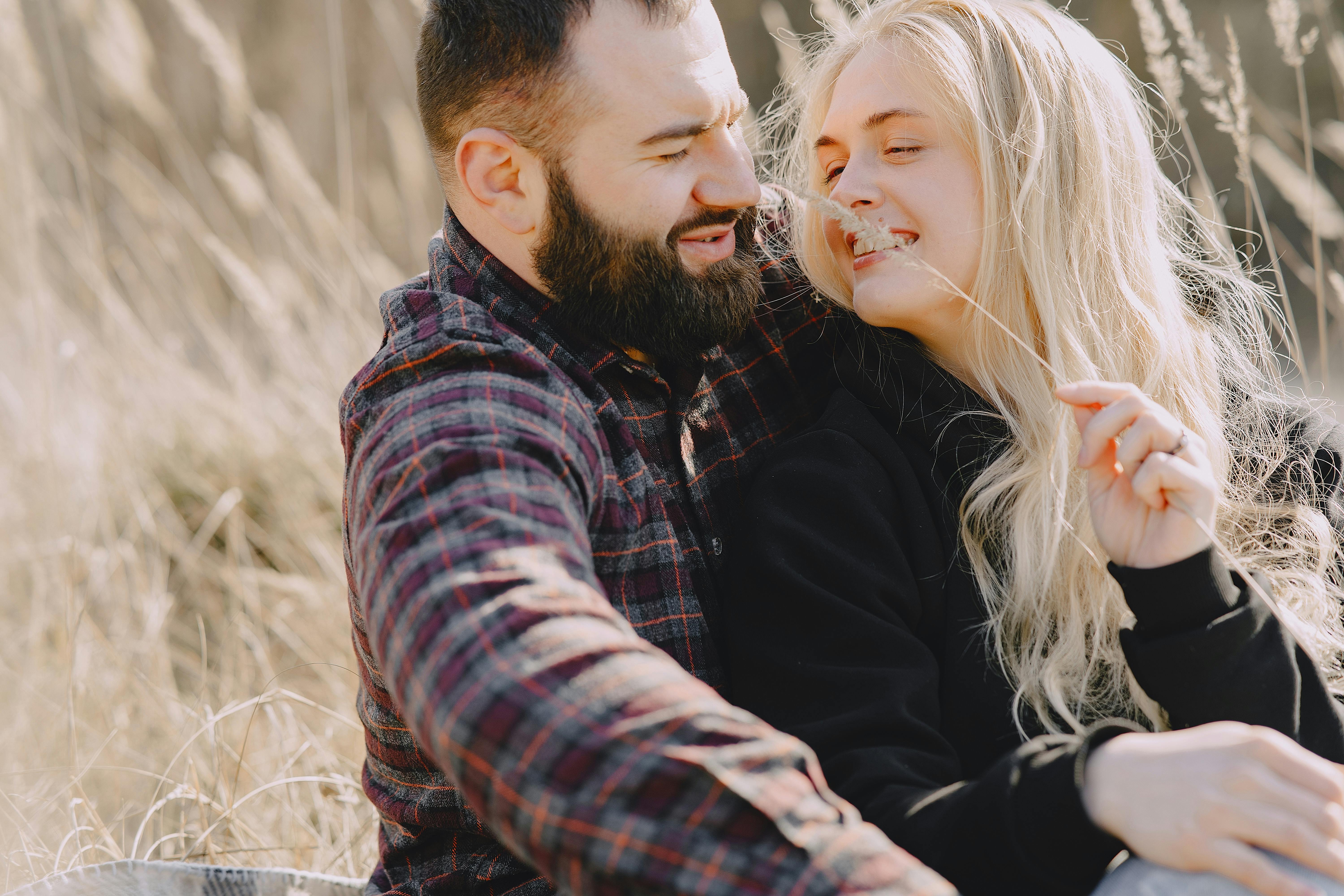 Cheerful girlfriend tickling happy boyfriend with ear of wheat · Free Stock  Photo