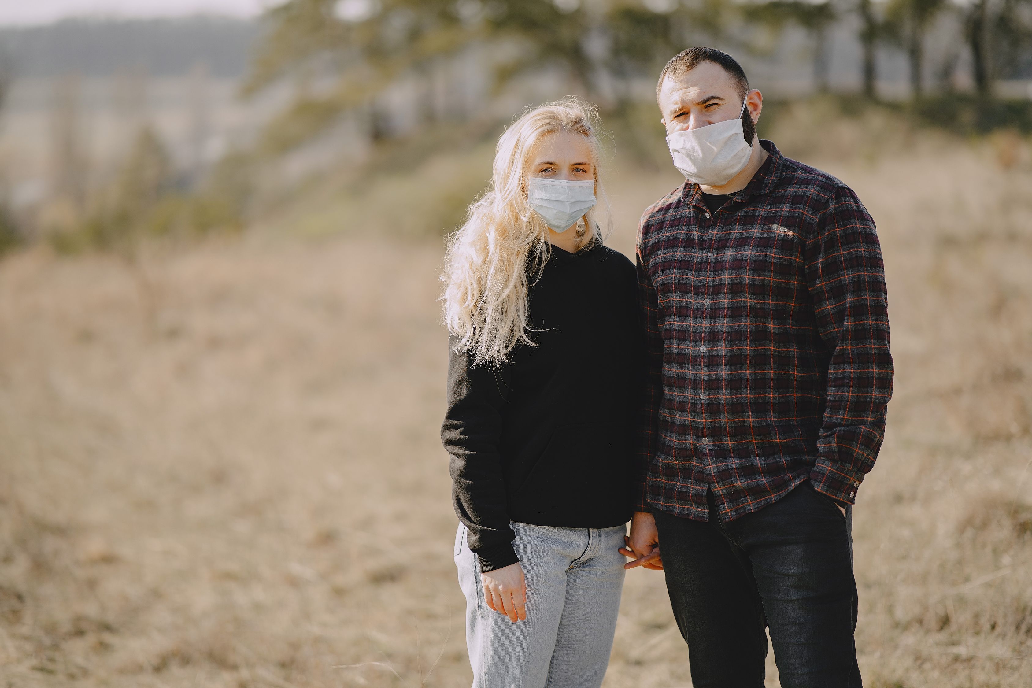 Serious couple wearing face masks in countryside · Free Stock Photo