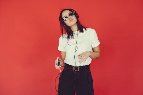 Stylish young woman listening to music in headphones