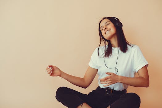 A happy woman with closed eyes listens to music using headphones in a studio setting.