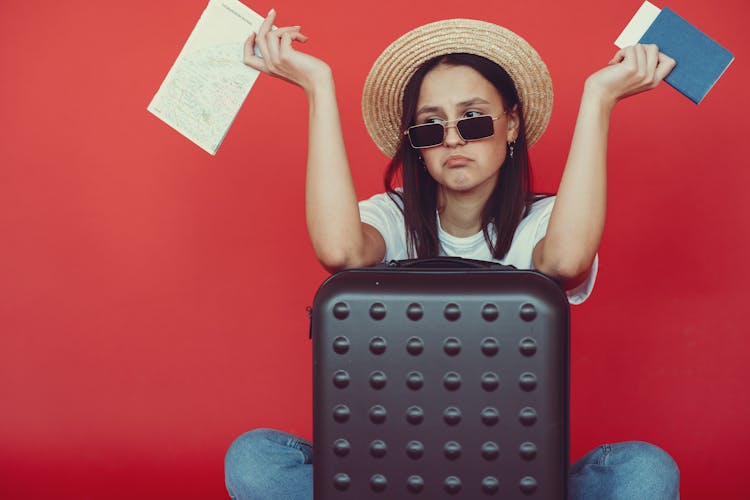 Anxious Young Lady With Tickets And Passport On Red Background