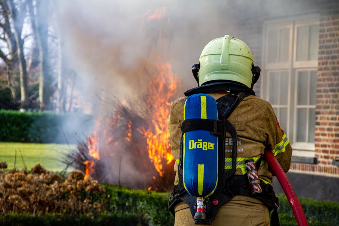 Man with Green Helmet Putting Out Fire