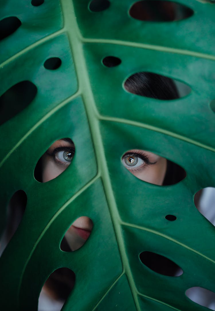 Serious Woman Looking Through Foliage