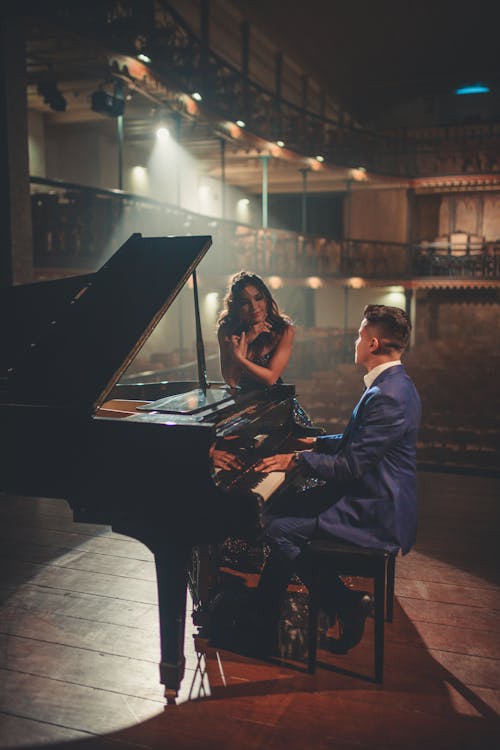 Man playing piano for woman
