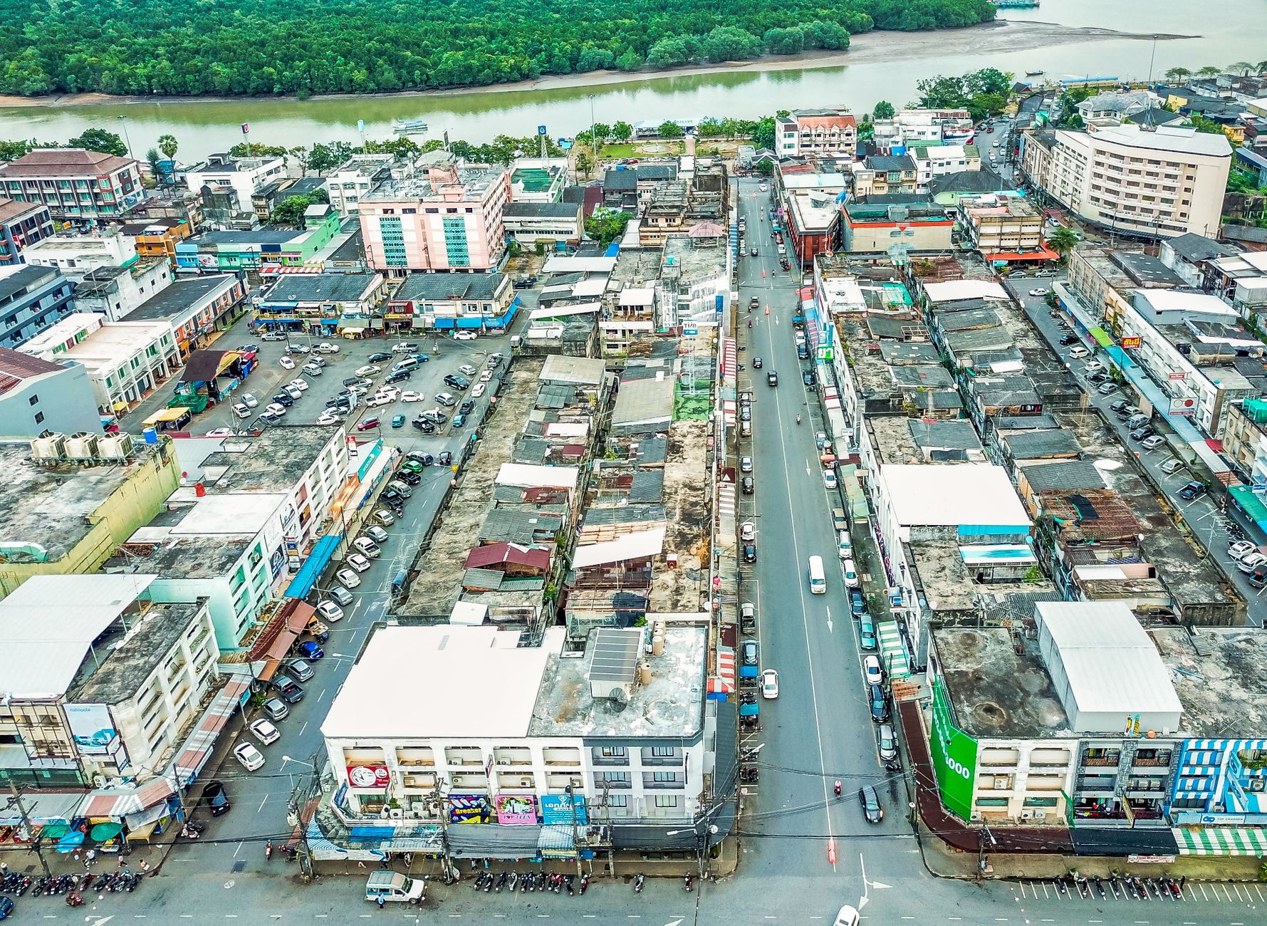 A vibrant aerial view of a bustling cityscape in Thailand showcasing streets, buildings, and a river.