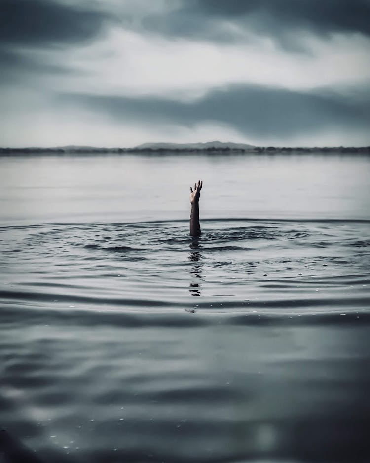 Hand Reaching Out Of A Person Drowning In Water