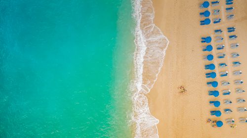 Free A stunning aerial capture of Lefkada beach with turquoise waters, blue umbrellas, and soft golden sand. Stock Photo
