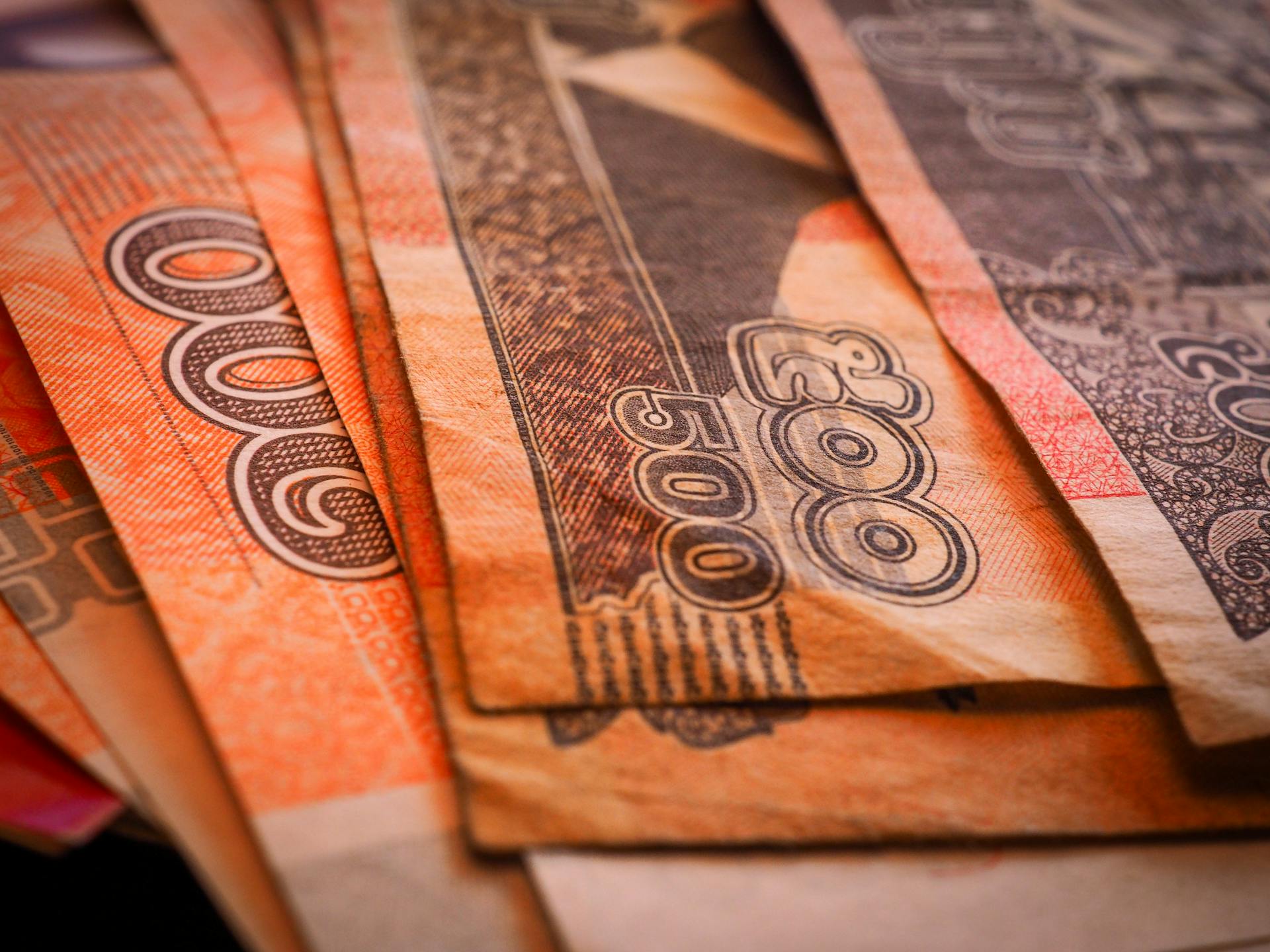 Macro shot of Cambodian Riel banknotes in a fanned arrangement displaying intricate designs and denominations.