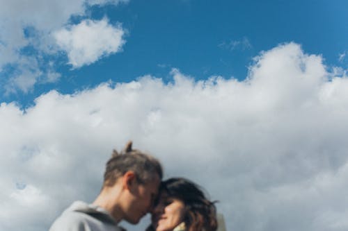 Loving couple embracing against bright sky
