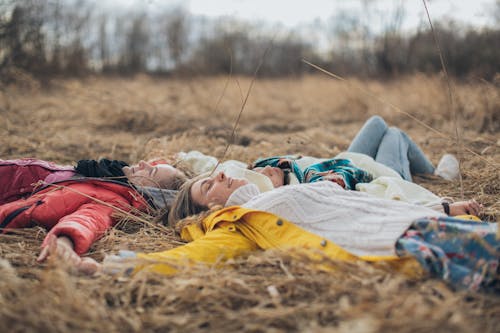 Расслабленные друзья лежат на траве в кругу