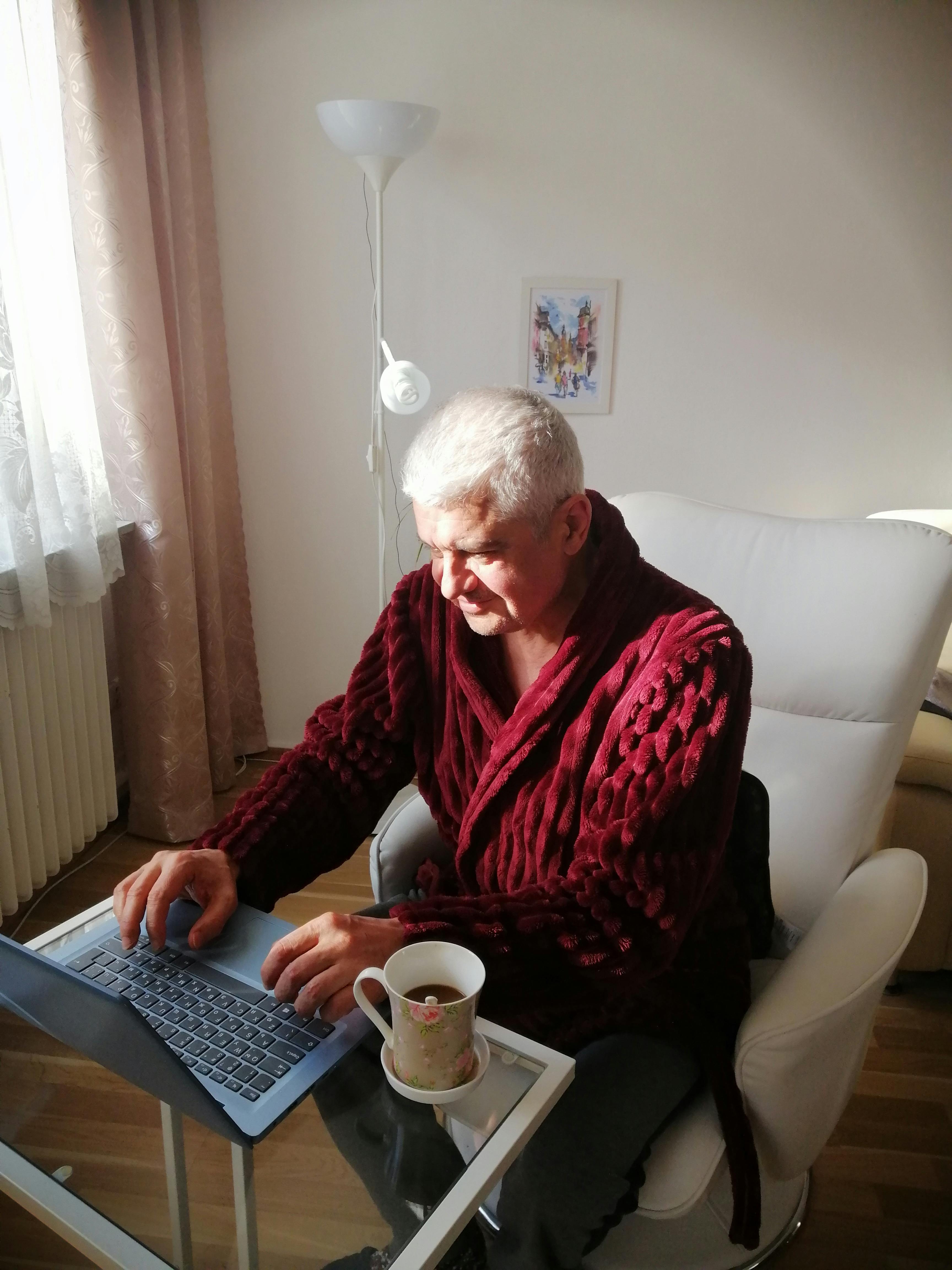 focused senior man using laptop in living room