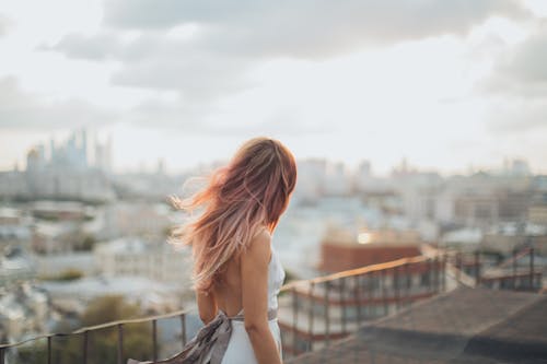 Young woman standing on rooftop during sunset