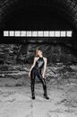 Stylish young woman standing in dirty hangar