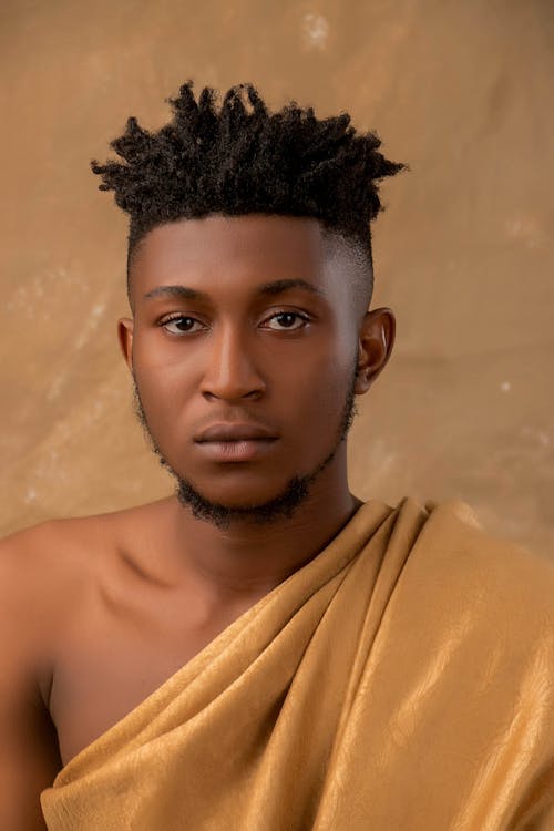 A Man in Gold Traditional Wear Seriously Looking at the Camera