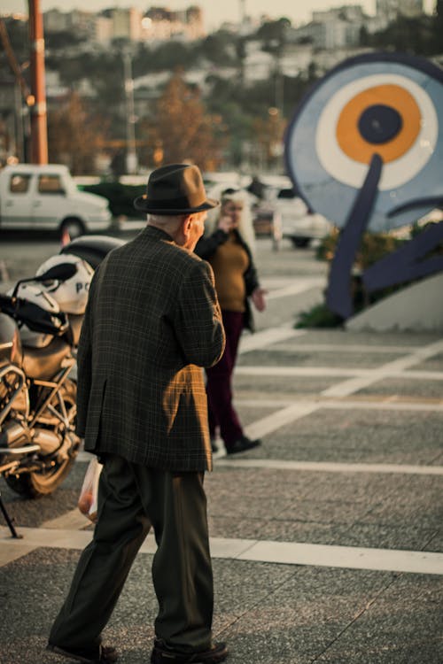 Foto profissional grátis de abrigo, andando, chapéu fedora