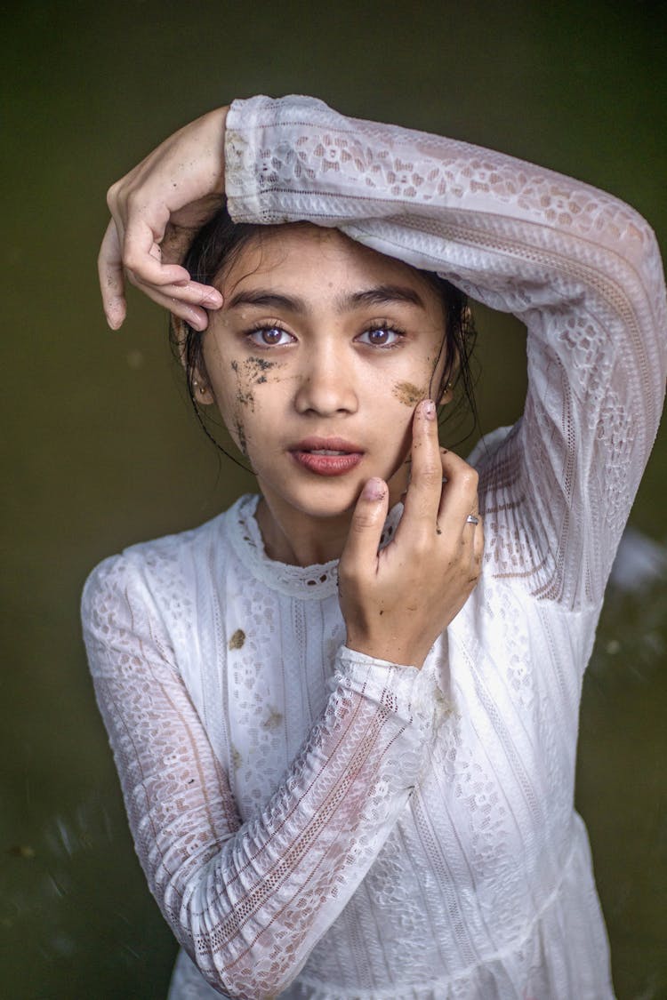 Young Ethnic Teen In White Dress And With Mud On Face