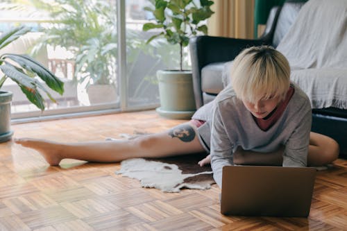 Free Focused woman using laptop on floor Stock Photo
