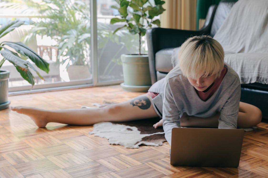 Focused woman using laptop on floor