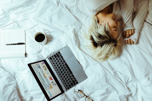 Free Young woman using laptop in bed and resting Stock Photo