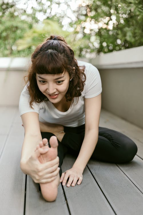 Young happy woman stretching on balcony