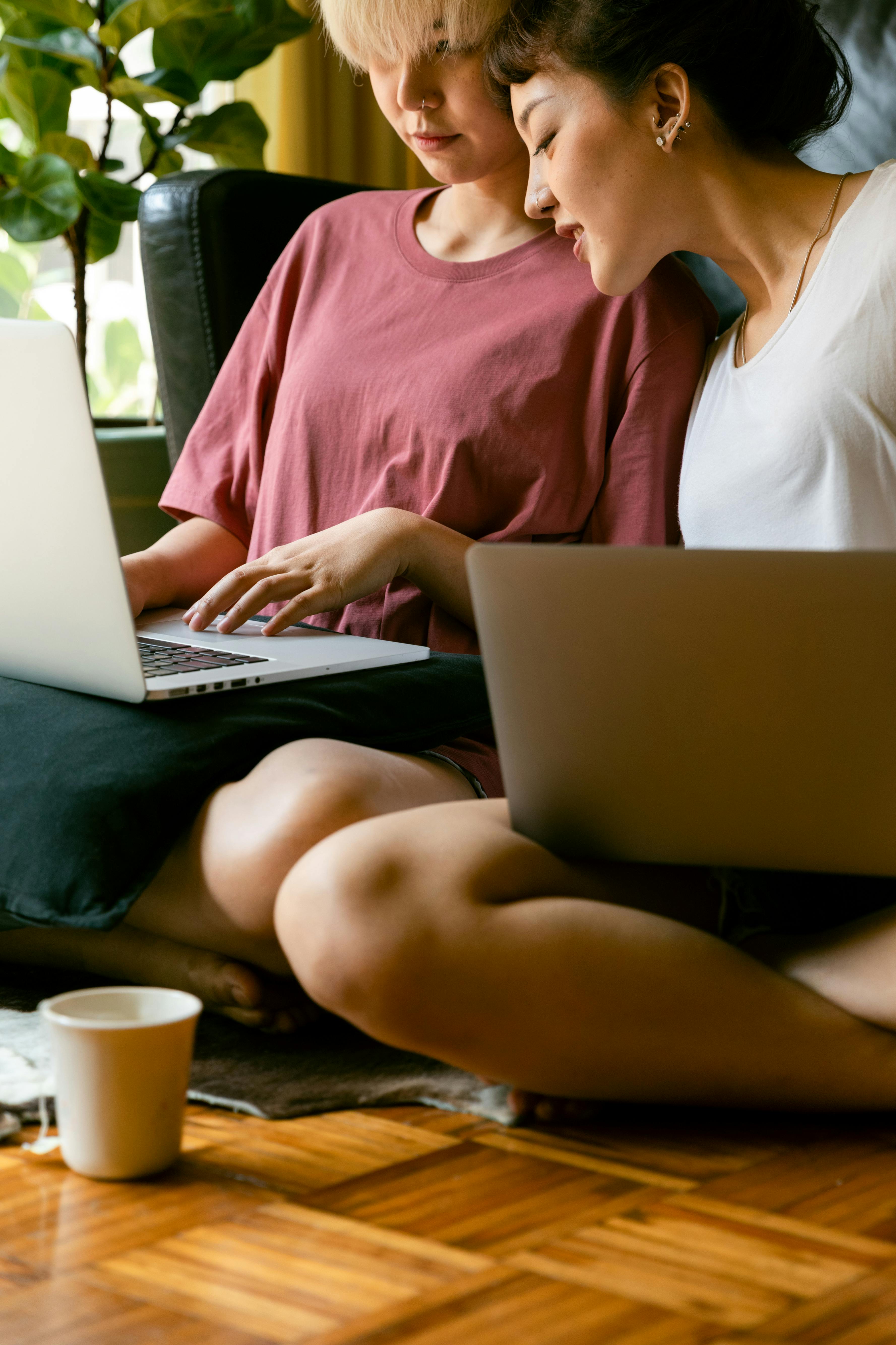 women using laptops and sitting on the floor