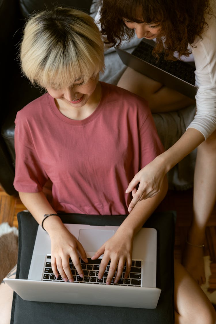 Woman Pointing At Her Friends Laptop