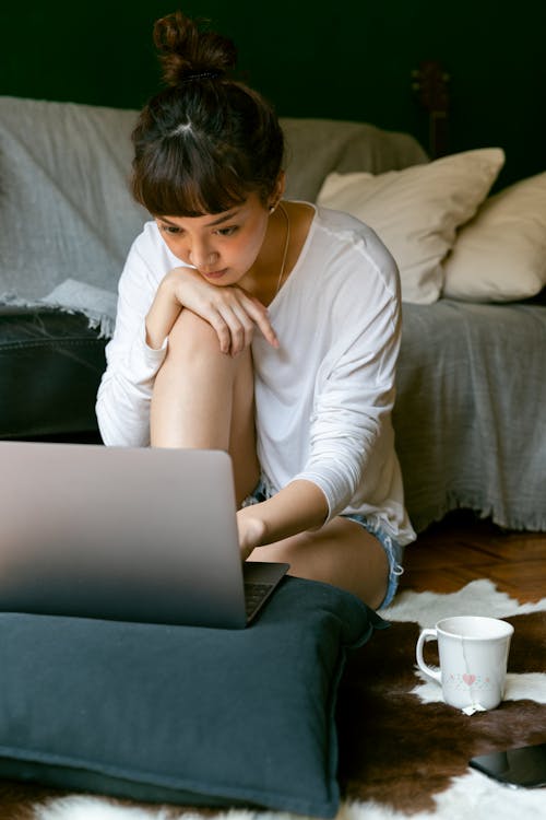 Free Focused ethnic woman using laptop at home Stock Photo