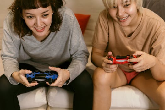 Two women playing video games with controllers, enjoying leisure time indoors.