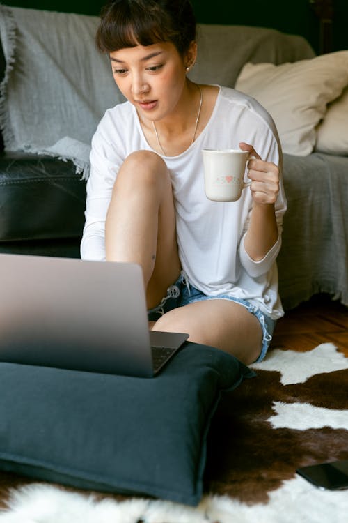 Asian female freelancer working on laptop in living room