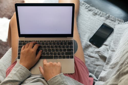Free Crop unrecognizable freelancer typing on laptop with blank screen Stock Photo