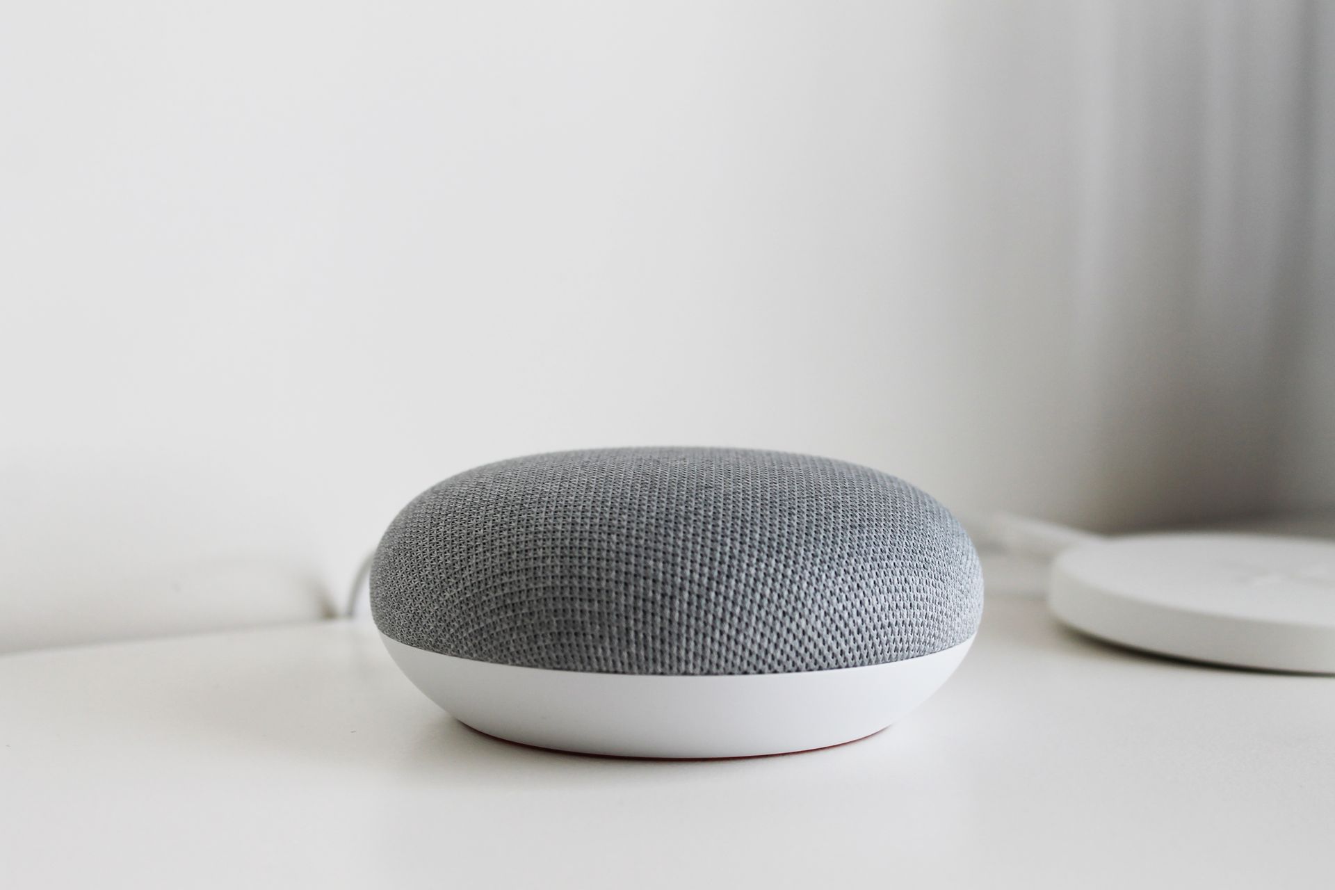 A minimalist smart speaker device on a tabletop