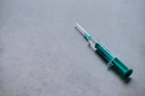 Green Syringe on a Gray Surface