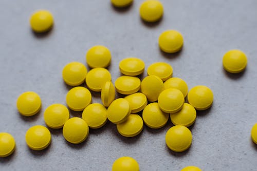 Yellow Medication Pills on Gray Surface