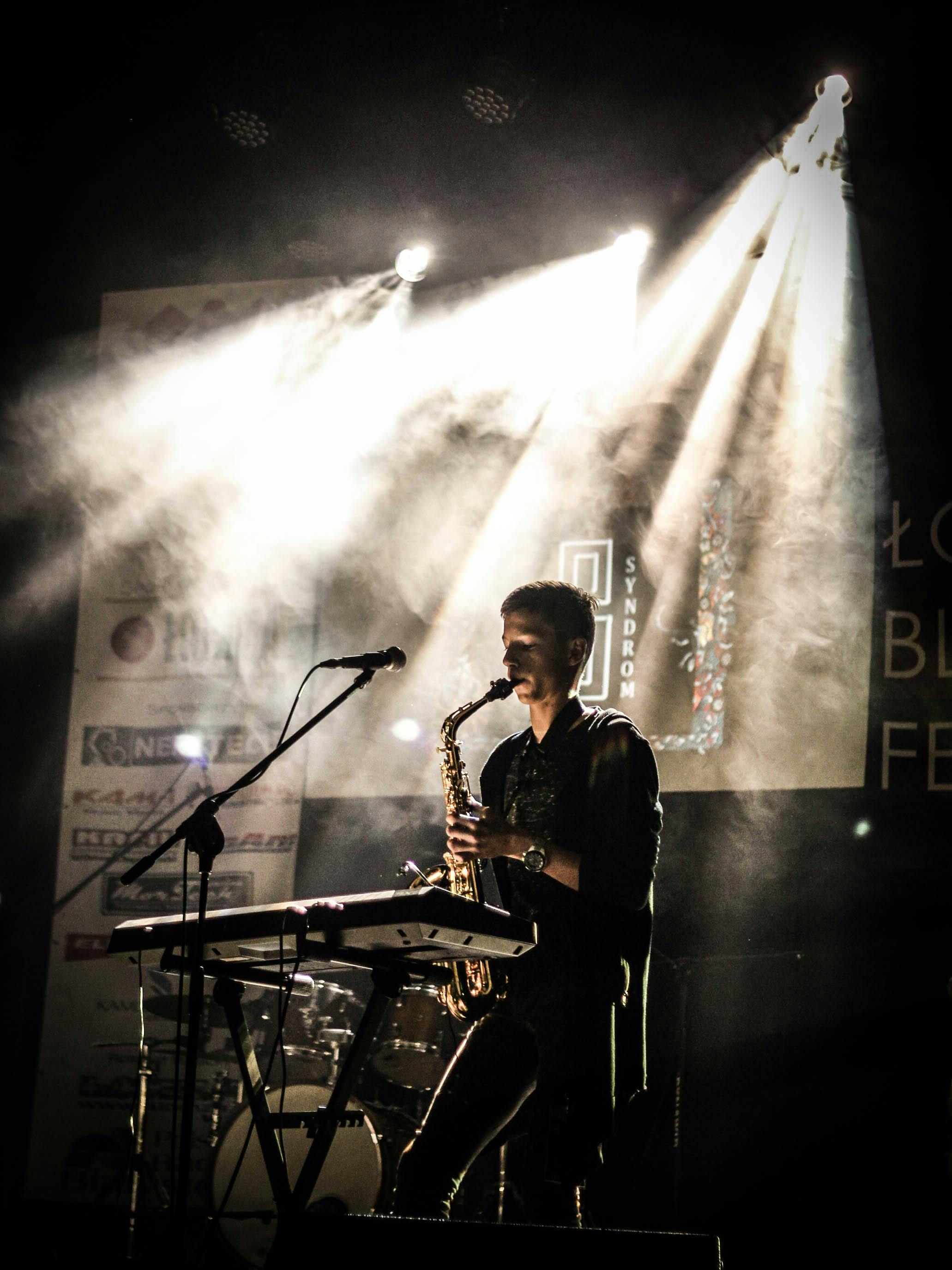 musician playing saxophone on illuminated stage