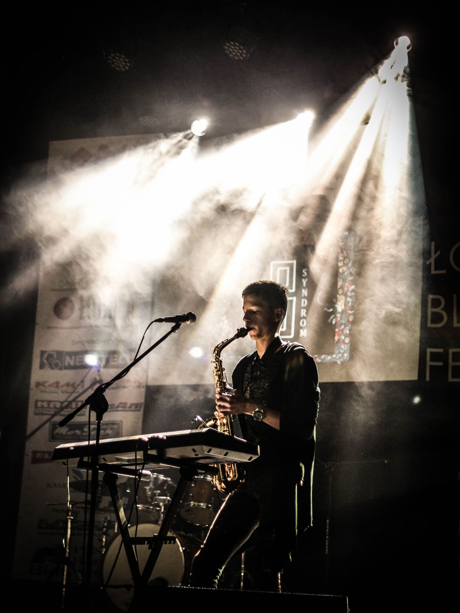 A saxophonist performing under stage lights